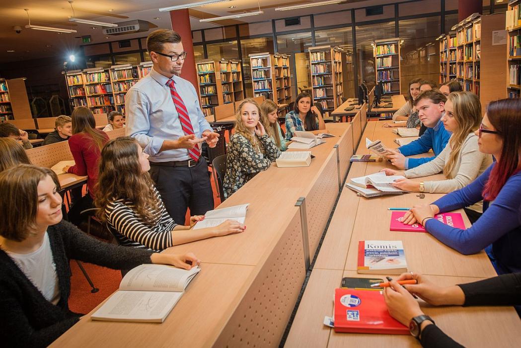 Studenci na zajęciach słuchają wykładowcy. 