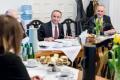 Uczestnicy spotkania siedzą przy wspólnym stole. 