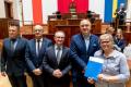 Przedstawiciele gmin odbierają umowy w Sali Sejmu Śląskiego. 