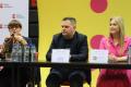 Uczestnicy konferencji siedzą przy stole. 