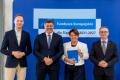 Osoby wręczające oraz beneficjenci odbierający listy gratulacyjne. 