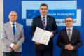 Osoby wręczające oraz beneficjenci odbierający listy gratulacyjne. 