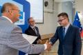 Osoby wręczające oraz beneficjenci odbierający listy gratulacyjne. 