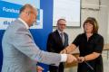 Osoby wręczające oraz beneficjenci odbierający listy gratulacyjne. 