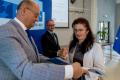 Osoby wręczające oraz beneficjenci odbierający listy gratulacyjne. 