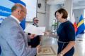 Osoby wręczające oraz beneficjenci odbierający listy gratulacyjne. 