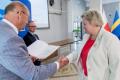 Osoby wręczające oraz beneficjenci odbierający listy gratulacyjne. 