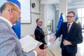 Osoby wręczające oraz beneficjenci odbierający listy gratulacyjne. 