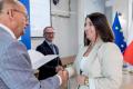Osoby wręczające oraz beneficjenci odbierający listy gratulacyjne. 