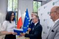 Uczestnicy uroczystości odbierają listy gratulacyjne. 