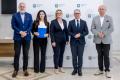 Uczestnicy uroczystości odbierają listy gratulacyjne. 