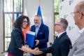 Uczestnicy uroczystości odbierają listy gratulacyjne. 