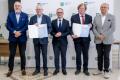 Uczestnicy uroczystości odbierają listy gratulacyjne. 