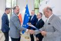 Uczestnicy uroczystości odbierają listy gratulacyjne. 