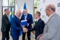 Uczestnicy uroczystości odbierają listy gratulacyjne. 