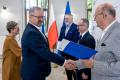 Uczestnicy uroczystości odbierają listy gratulacyjne. 