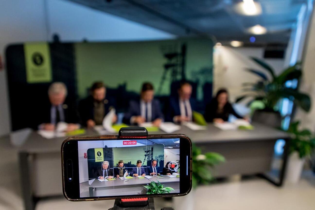 Wicemarszałek Województwa Śląskiego Leszek Pietraszek przemawia na podium w Muzeum Śląskim w Katowicach, omawiając potencjał wykorzystania wód pokopalnianych w energetyce odnawialnej. (wygenerowano przez AI)