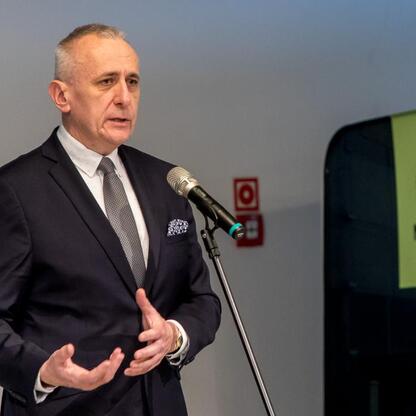 Wicemarszałek Województwa Śląskiego Leszek Pietraszek przemawia na podium w Muzeum Śląskim w Katowicach, omawiając potencjał wykorzystania wód pokopalnianych w energetyce odnawialnej. (wygenerowano przez AI)