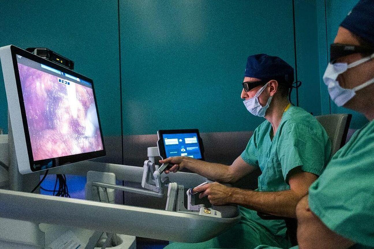 Dwa medycy w zielonych szortach i kaskach, pracujący z systemem robotycznym HUGO RAS w nowoczesnym szpitalu. (wygenerowano przez AI)