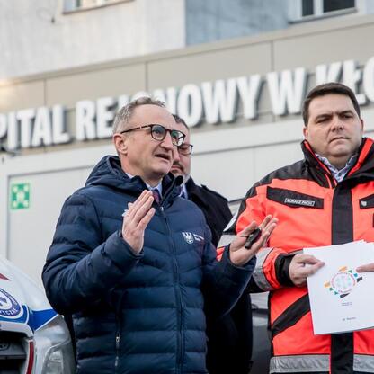Grzegorz Boski, wicemarszałek województwa śląskiego, prezentuje dokument na tle Regionalnego Szpitala Specjalistycznego w Kłobucku. (wygenerowano przez AI)