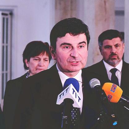 Politolog Marcin Ryś przemawia na konferencji prasowej, otaczony przez mikrofony i oficjalne logo województwa śląskiego. (wygenerowano przez AI)