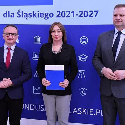 Trzech przedstawicieli administracji podczas ceremonii wręczenia nagród za projekty energetyczne w ramach Funduszu Sprawiedliwej Transformacji dla Śląska. (wygenerowano przez AI)