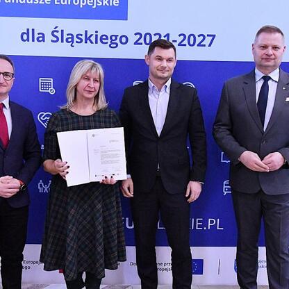 Grzegorz Boski i Rafał Adamczyk wręczają listy gratulacyjne za sukcesy w projekcie Funduszy Europejskich dla Śląska 2021-2027. (wygenerowano przez AI)