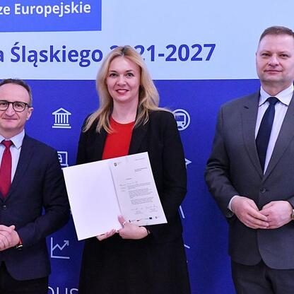 Wicemarszałek Grzegorz Boski i członek Zarządu Województwa Rafał Adamczyk wręczają listy gratulacyjne przedstawicielom gmin z funduszy europejskich dla Śląska 2021-2027. (wygenerowano przez AI)