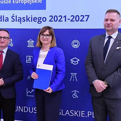 Rafał Adamczyk i Grzegorz Boski wręczają listy gratulacyjne przedstawicielom gmin w ramach projektu Funduszy Europejskich dla Śląska 2021-2027. (wygenerowano przez AI)
