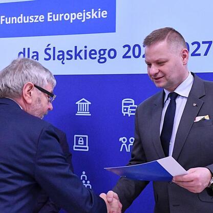 Członek Zarządu Województwa Rafał Adamczyk wręcza dokument przedstawicielowi gminy w ramach funduszy dla energetyki odnawialnej. (wygenerowano przez AI)