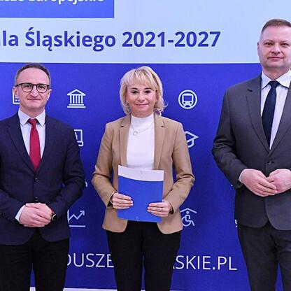 Trzech przedstawicieli Województwa Śląskiego przedstawiają projekt funduszy dla odnawialnych źródeł energii. (wygenerowano przez AI)
