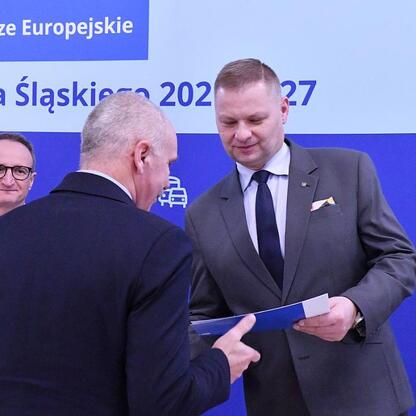 Członkowie Zarządu Województwa Śląskiego i Wicemarszałek Grzegorz Boski wręczają listy gratulacyjne za sukcesy w programie Funduszy Europejskich dla Śląska. (wygenerowano przez AI)