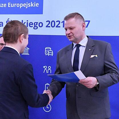 Rafał Adamczyk, członek Zarządu Województwa Śląskiego, gratuluje wybranym gminom w ramach projektów odnawialnych źródeł energii. (wygenerowano przez AI)