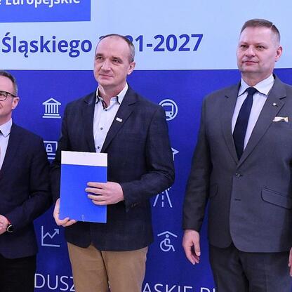 Trzech mężczyzn przedstawiających listy gratulacyjne w ramach projektu finansowanego z Europejskich Funduszy dla Śląska 2021-2027. (wygenerowano przez AI)
