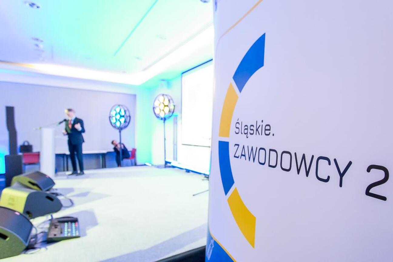 Grupa ludzi w strojach formalnych siedzi w konferencji dotyczącej projektu "Śląskie. Zawodowcy 2". (wygenerowano przez AI)