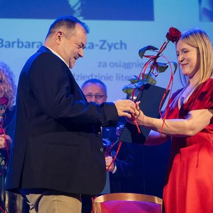 Joanna Bojczuk, członek Zarządu Województwa Śląskiego, wręcza nagrodę laureatce w dziedzinie literatury, Barbara Gruszka-Zych. (wygenerowano przez AI)