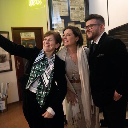 Trzech osób w strojach formalnych robią selfie w trakcie uroczystości nagród Marszałka Województwa Śląskiego. (wygenerowano przez AI)