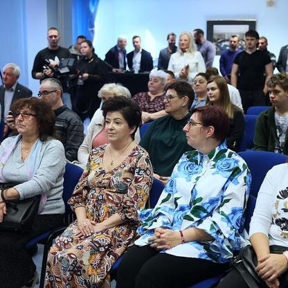 Zajęta grupa ludzi w audytorium, uczestnicząca w prezentacji z użyciem robota da Vinci w onkologii. (wygenerowano przez AI)