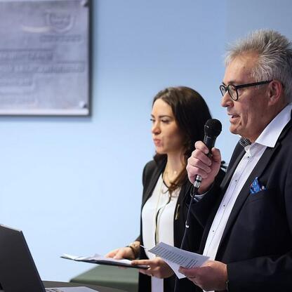 Podczas konferencji w Katowickim Centrum Onkologii, wykładowca prezentuje zaawansowane technologie chirurgiczne, w tym robotyka da Vinci, podkreślając ich wpływ na leczenie raka. (wygenerowano przez AI)