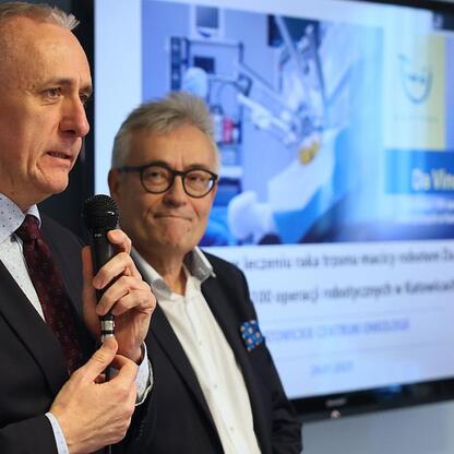 Podczas konferencji w Katowickim Centrum Onkologii Leszek Pietraszek i Włodzimierz Migacz omawiają zalety robota da Vinci w leczeniu raka trzonu macicy. (wygenerowano przez AI)