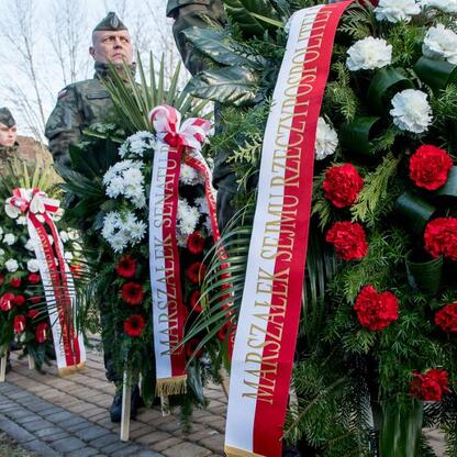 Słupski pomnik Ofiar Tragedii Górnośląskiej, uczestnicy składają kwiaty i wieniec. (wygenerowano przez AI)