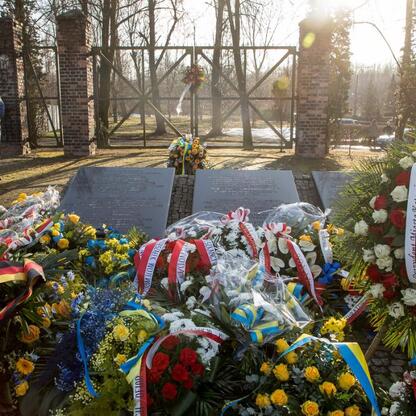 Słup pomnikowy z inskrypcjami i kwiatami upamiętnia ofiary Tragedii Górnośląskiej, zlokalizowany w miejscu pamięci w Bytomiu-Miechowicach. (wygenerowano przez AI)