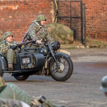 Historia i pamięć. Grupa w mundurach wojskowych na motocyklach z sidecarami, rekonstrukcja wydarzeń z okresu Tragedii Górnośląskiej. (wygenerowano przez AI)
