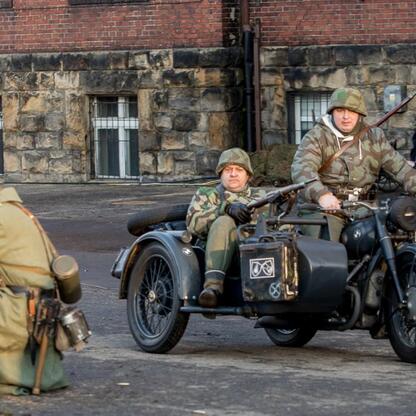 Rekonstrukcja wydarzeń z 1945 r. w Śląsku, uczestnicy w mundurach wojskowych. (wygenerowano przez AI)