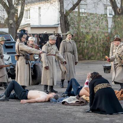 Rekonstrukcja z 1945 r. Tragedii Górnośląskiej, uczestnicy w mundurach i z bronią. (wygenerowano przez AI)
