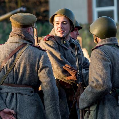 Grupa wojowników w historycznych mundurach uczestniczy w rekonstrukcji wydarzeń z 1945 roku, upamiętniających Tragedię Górnośląską. (wygenerowano przez AI)