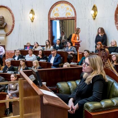 Formalne spotkanie w Sejmiku Osób z Niepełnosprawnością Województwa Śląskiego, gdzie Monika Sikora podkreśla znaczenie dostępności dla osób z niepełnosprawnościami. (wygenerowano przez AI)
