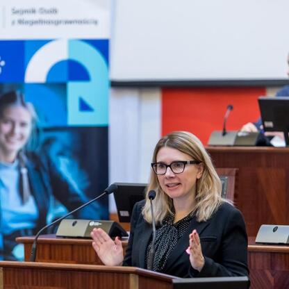 Monika Sikora, podsekretarz stanu w MFPR, przemawia na sesji Sejmiku Osób z Niepełnosprawnością Województwa Śląskiego. (wygenerowano przez AI)