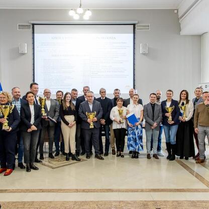 Grupa osób z nagrodami i dyplomami na Śląskim Szkolnym Związku Sportowym w Katowicach. (wygenerowano przez AI)
