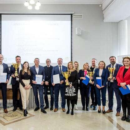 Grupa osób otrzymuje nagrody za sukcesy w programie 